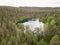 Clear forest lake behind trees