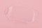 Clear gel smear isolated on pink background. Top view. Serum texture