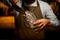 clear glass in bartender hand and pouring pieces of ice into it using steel scoop