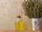 A clear glass bottle with oil and fresh thyme branches in a miniature bucket on a wooden table, cosmetic procedure oil