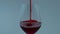 Clear gourmet liquor flowing down wineglass closeup. Red wine streaming in glass
