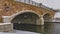 Clear Panorama Stone arched bridge with lamps over a lake during winter in Daybreak Utah