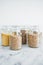 Clear pantry jars with different types of grains in them including quinoa rice buckwheat couscous and barley, simple na