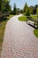 A clear path in the park, brightly lit by the sun, with a beautiful lounge bench