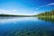 a clear, placid lake under a blue sky