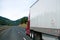 Clear red big rig semi truck white dry van trailer in perspective road sky