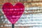 Clear Red Heart On Coil Spring. Metallic Foil Background With Angled Silver Shiny Stripes, Orange Highlights. Valentines Day,