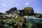 Clear sea water surrounded rocky island with blue sky background at sunny day.