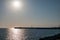 Clear sky and bright sunset at sea port with a breakwater and a lighthouse