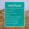 Clear Square Close up of a Park Rules signage against a rocky and grassy landscape