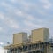 Clear Square Cloudy blue sky viewed behind the towers and buildings of a Power Plant