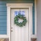 Clear Square Facade of a home with a simple leafy wreath hanging on the white front door