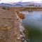 Clear Square Lake with rocks lining the shore and an arched bridge over its shiny water