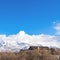 Clear Square Magnificent mountain coated with snow against a vivid sky with puffy clouds