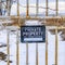 Clear Square Rusty white metal gate with a sign that reads Private Property No Trespassing