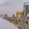 Clear Square Trail on snow covered ground along a fence with colorful lights in winter