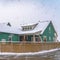 Clear Square Winter view of a colorful home with wooden fence against cloudy sky in Daybreak