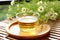 clear teacup filled with chamomile tea resting on a bamboo mat