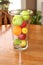 Clear vase with fresh fruit on wooden table