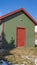 Clear Vertical Small storage shed on grassy terrain with trees and powdery snow