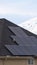 Clear Vertical Solar panels installed on the dark roof of a home with snow in winter