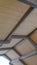 Clear Vertical Vertical Looking up at the roof of a pavilion with brown wooden planks and gray frames