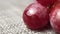 Clear water drips onto ripe red grapes close-up in slow motion