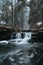 Clear water photographed with long exposure time through flowing rocks covered with moss with autumn colours of leaves. Krasna,