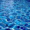 Clear water ripples over blue tiles, forming a mesmerizing abstract