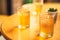 Clear wellness yellow drink lemonade, fruit tea, ice kombucha, green tea in two glasses on wooden table with small