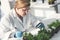 A clearer look is always needed. an attractive young female scientist making notes while analyzing plant samples with a