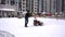 Clearing snow from paths in winter. Manual diesel tractor snow purifier. Grader. The area of the courtyard of a multi