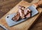 Cleaver knife slicing grilled steak on meat cutting wood board