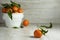 Clementine mandarines with green leaves on gray wooden background