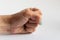 Clenched fist vigorously striking on white background