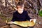 A clever boy searches an ancient map for something buried in a forest