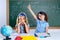 Clever nerd student girl in classroom raising hand