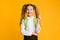 Clever School Girl Pointing Pencil Up Posing On Yellow Background