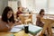 Clever schoolboy raising hand among his classmates