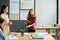 Clever schoolgirl with tablet in hand explaining something to classmates