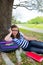 Clever student teen girl with school bag under park tree