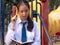 Clever teenage girl wearing school uniform writing book while thinking at the park, Nature, education, outdoor and study concept