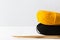 Clews of yellow black fine wool yarn wooden knitting needles on white table on wall background warm autumn color palette. Crafts