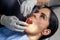 Client with the mouth open while a dentist examine her in a dental clinic