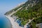 Cliff coastline with ocean and highest cliff with pine trees. Summer day on sea. Aerial view