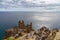 Cliff edge against ocean and cloudy sky