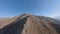 Cliff mountain ridge stone texture desert valley snowy summit clear blue sky aerial view