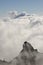 Cliff, sea of clouds and smoke plume from a volcanic eruption.