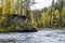 Cliff, stone wall, forest, waterfall and wild river view in autumn.