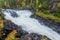 Cliff, stone wall, forest, waterfall and wild river view in autumn.